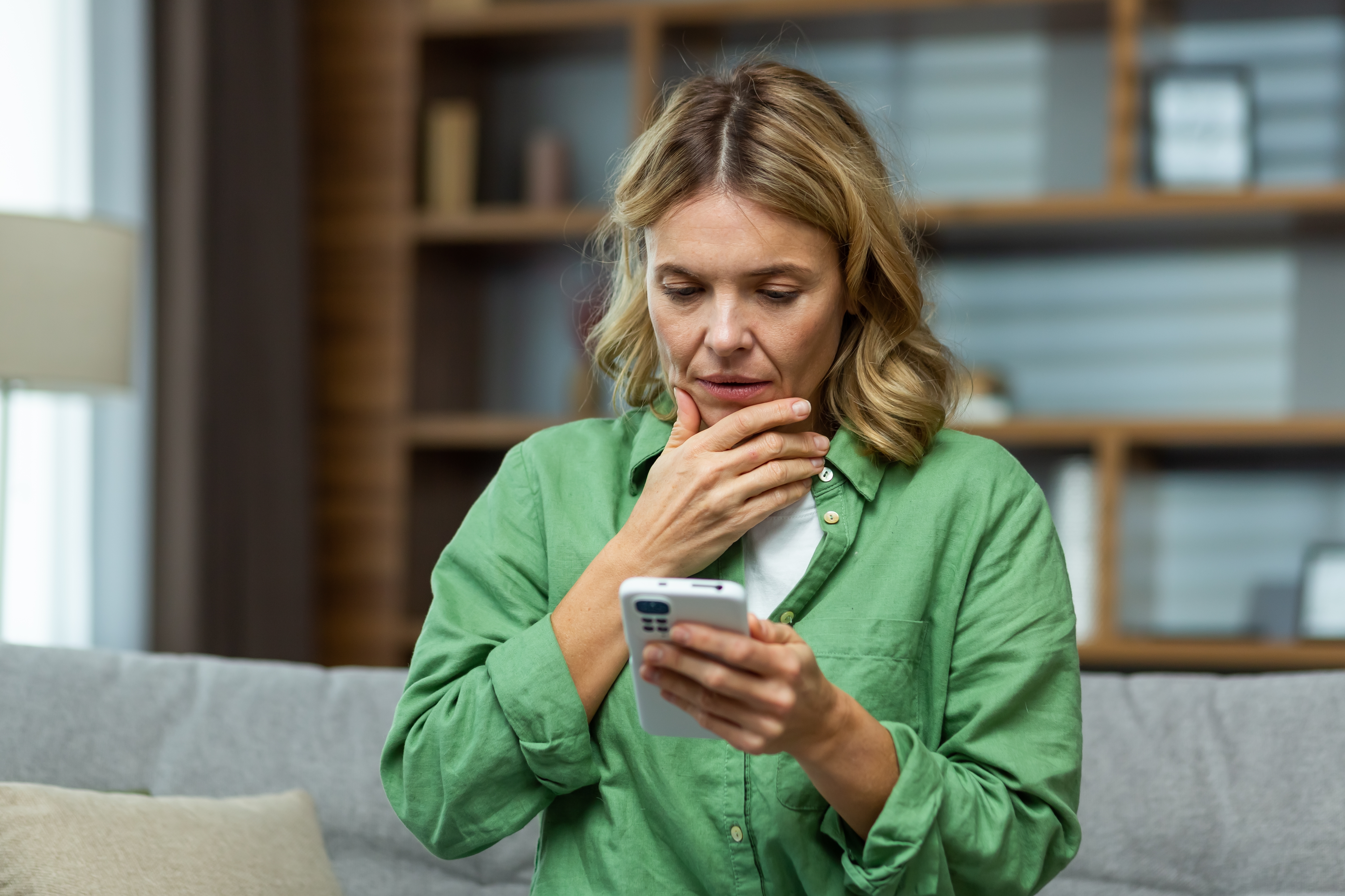 Une femme âgée inquiète tenant son téléphone | Source : Shutterstock