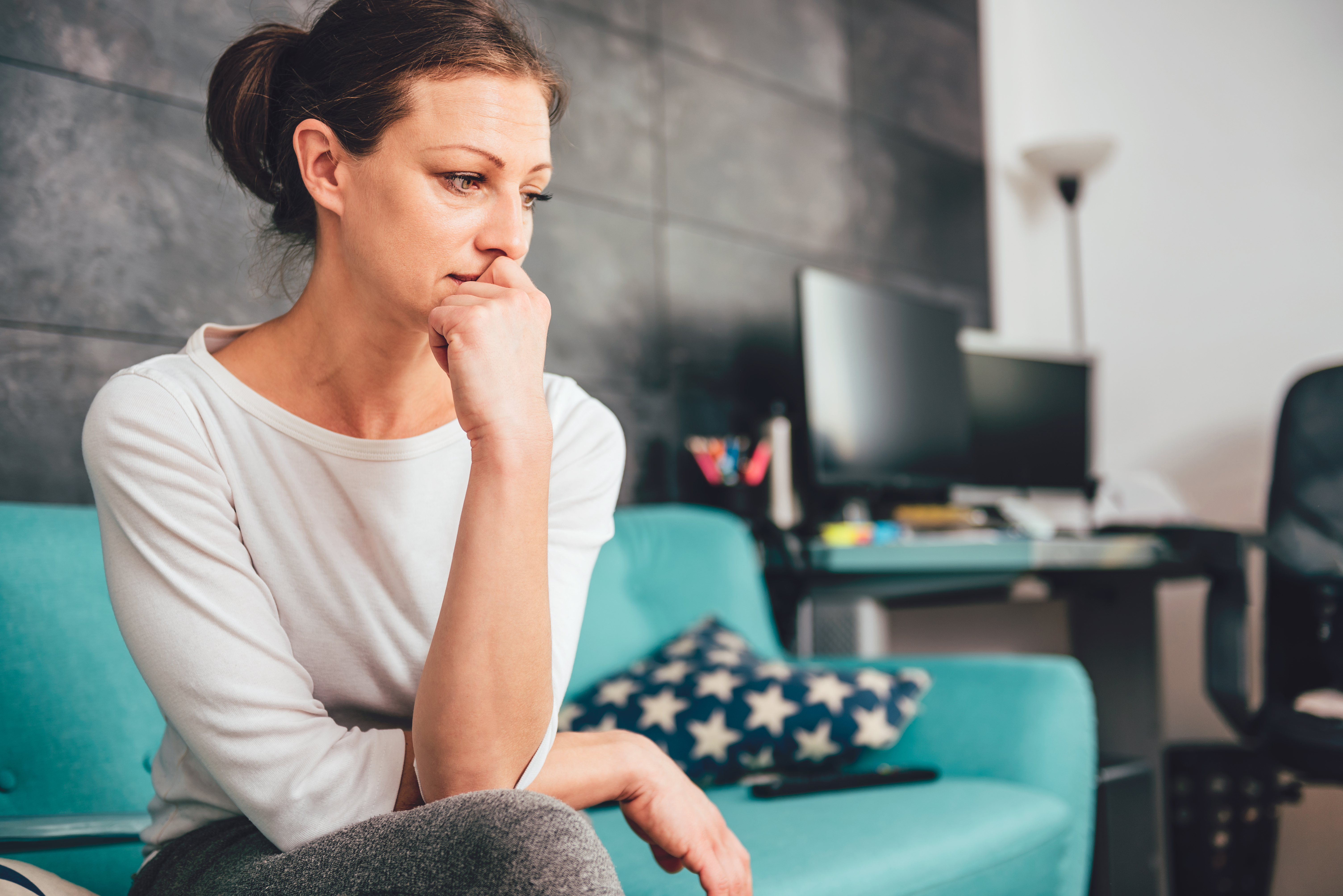 Une femme bouleversée assise sur le canapé | Source : Shutterstock