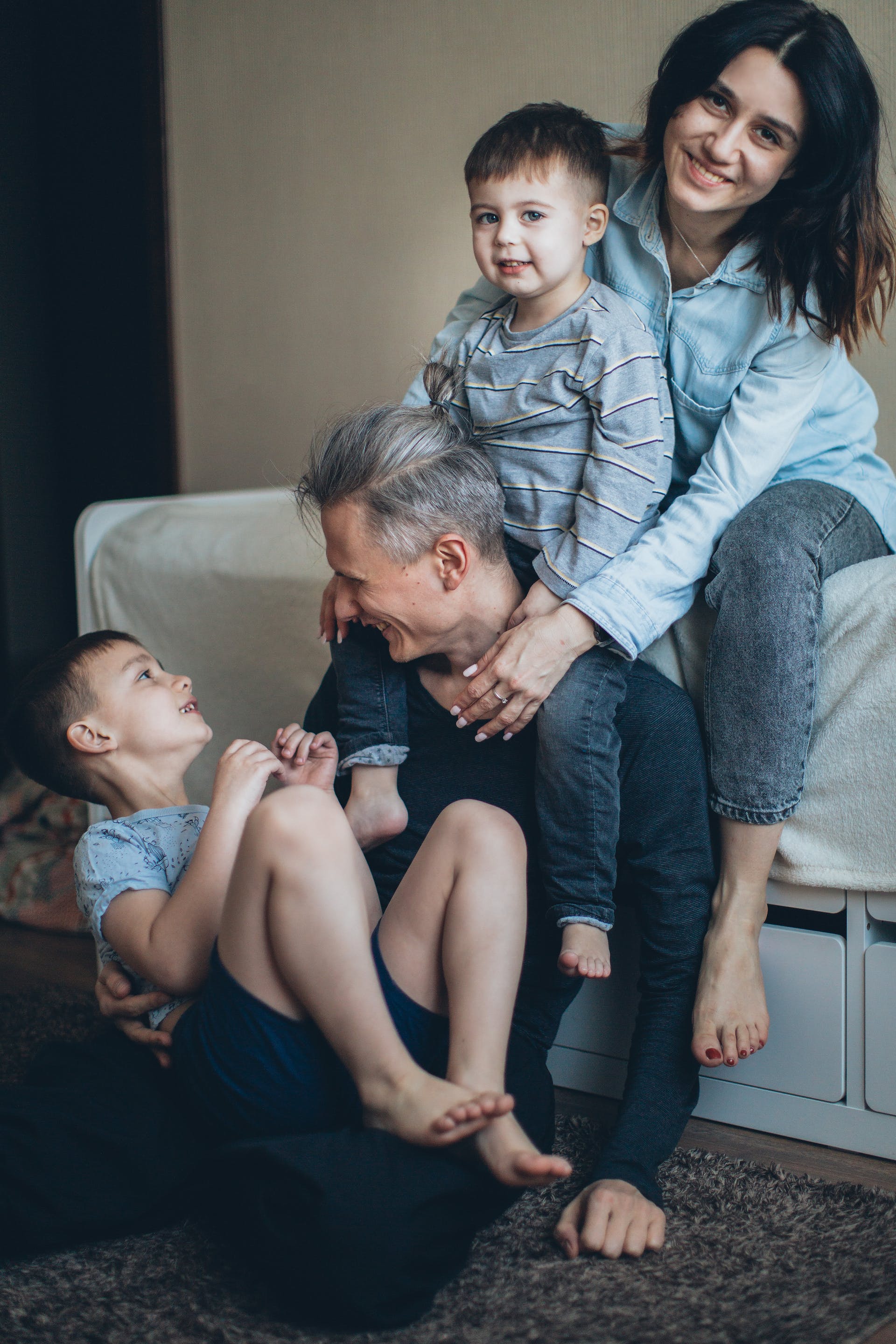 Un couple heureux qui joue avec ses deux fils | Source : Pexels